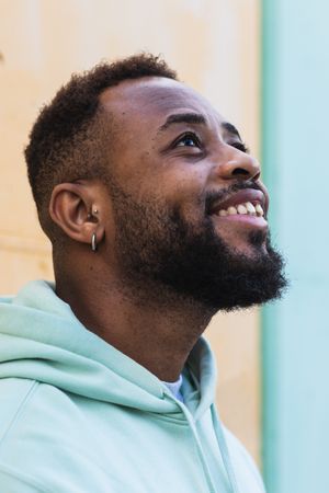Cheerful Black man standing near wall