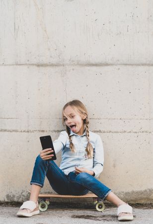 Kid using mobile phone with skate