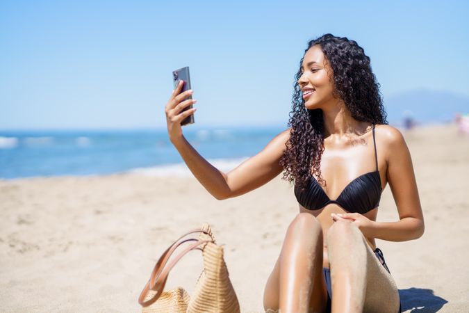 A Joyful Woman Happily Taking a Selfie at the Beach on a Beautiful, Sunny Summer Day