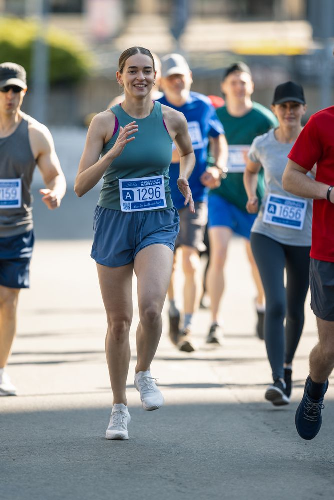 Diverse Group of People Running a Marathon in a City During the Day.