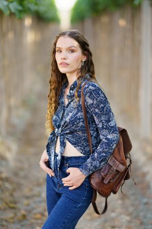 A Trendy Young Woman Posing Beautifully in a Scenic Vineyard While Wearing a Stylish Outfit