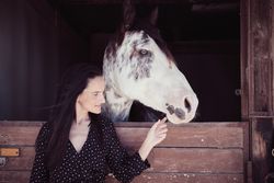Woman touching muzzle of horse