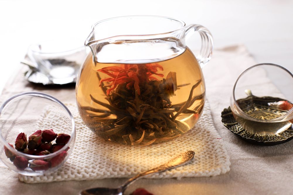Teapot and Glass Cup with Blooming Tea Flower Inside