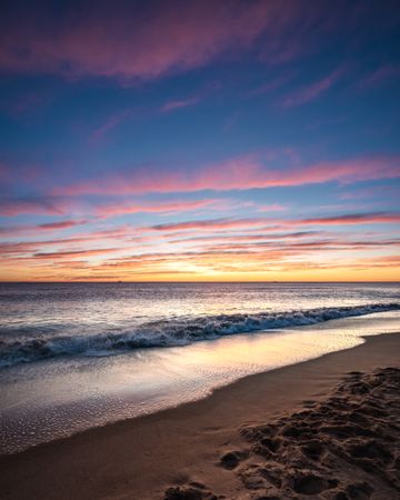 Calm waves on shore during golden hour