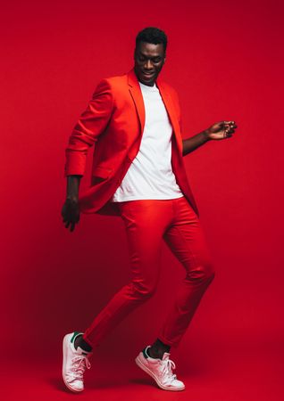 Man in stylish red outfit showing some dance moves