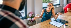Surprised woman arguing with colleague for problems in coworking