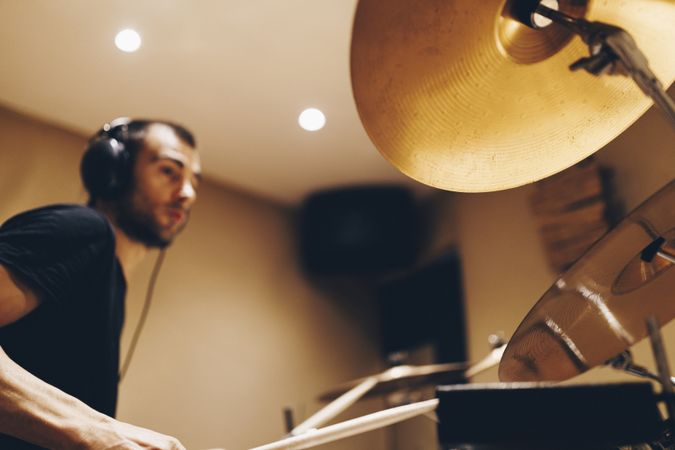 Man with headphones playing on drums