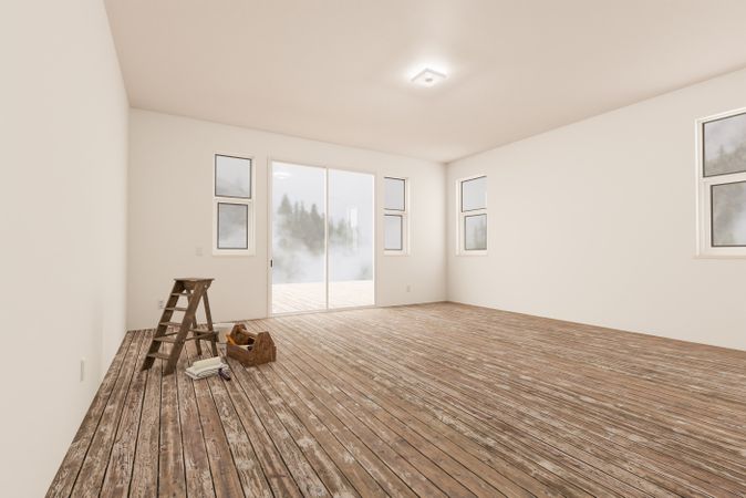 Ladder and Painting Equipment In Raw Unfinished Room of House with Blank Walls and Worn Wood Floors.