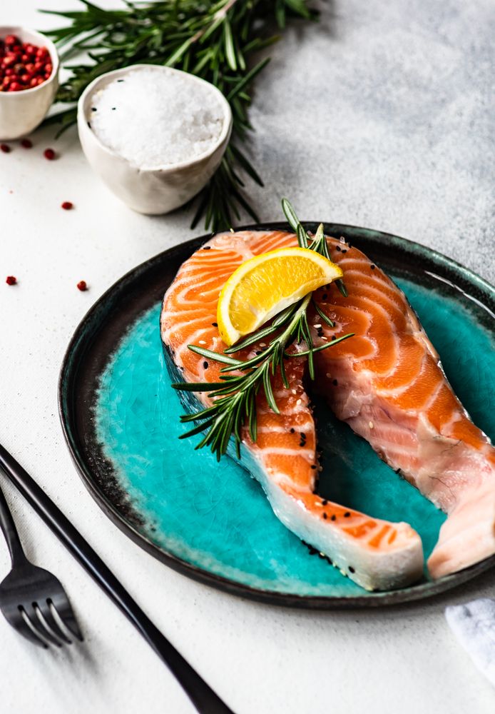 Salmon fish with rosemary and lemon on counter with copy space