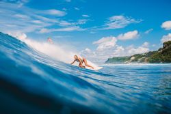 Woman surfing on sea waves