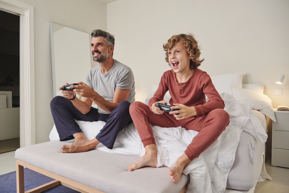 Happy man and child playing videogame at home
