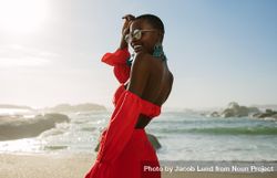 Beautiful woman in red dress enjoying on the beach 5XpOQ5