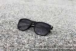 Sunglasses sitting on grey beach 0Vnnj0