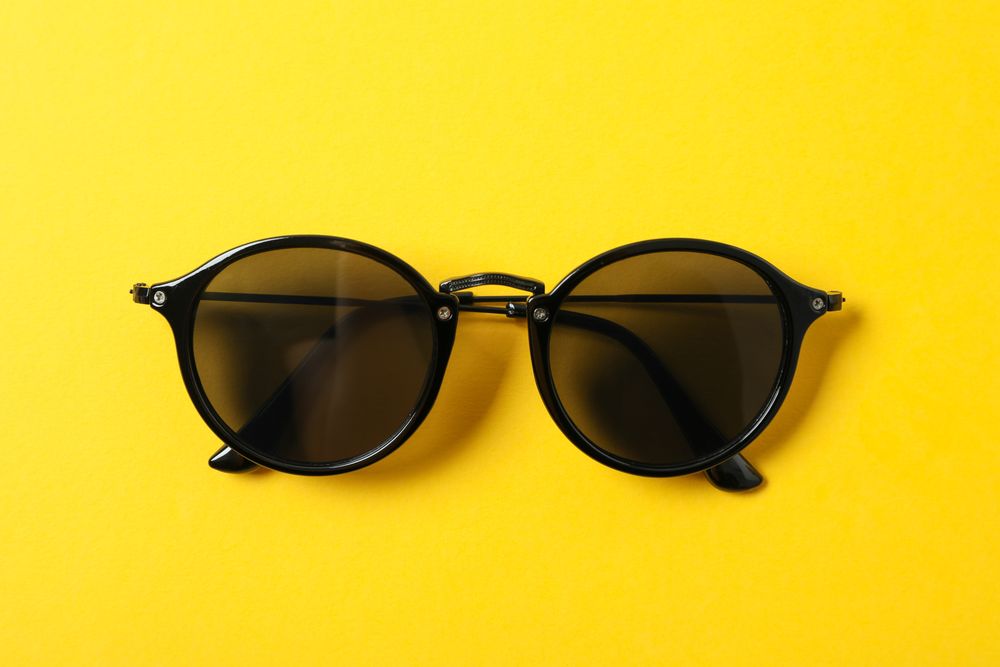Sunglasses on color background, space for text and closeup. Fashionable accessories