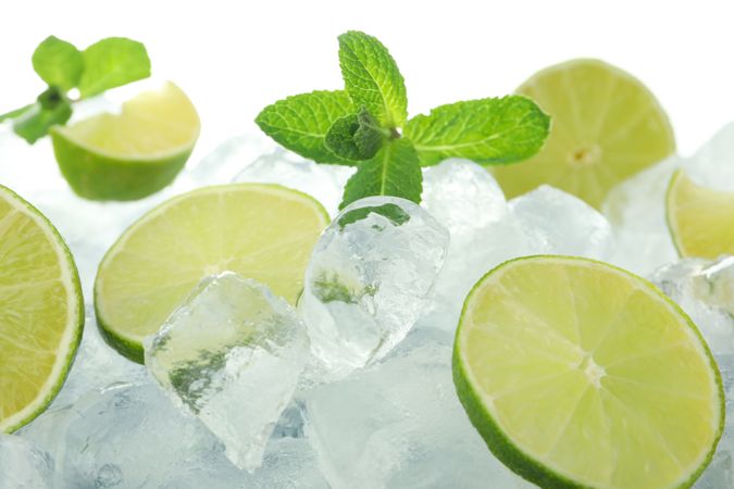 Pile of ice with lime halves and mint