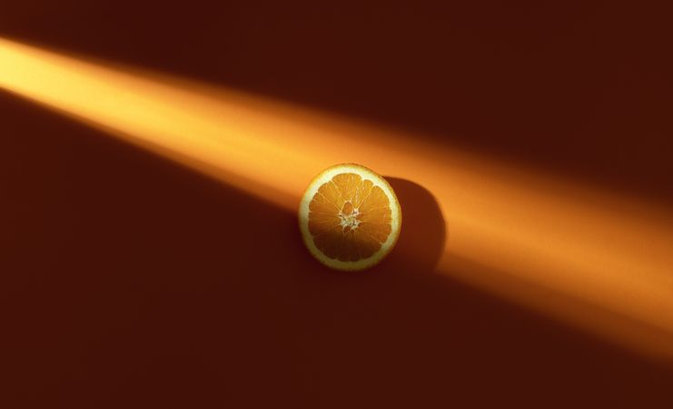 Orange slice in single sunlight ray