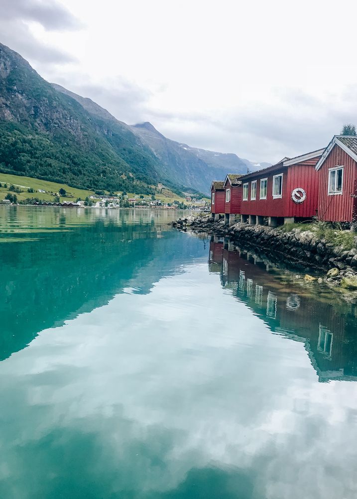 Red house beside lake with reflection