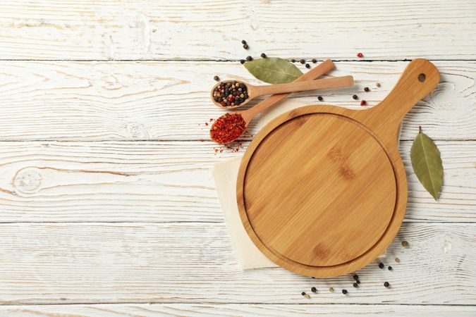 Composition with cutting board and spices on wooden background