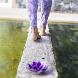 Shot of a purple glass lotus while a woman walks away.