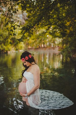 Pregnant woman standing in lake water