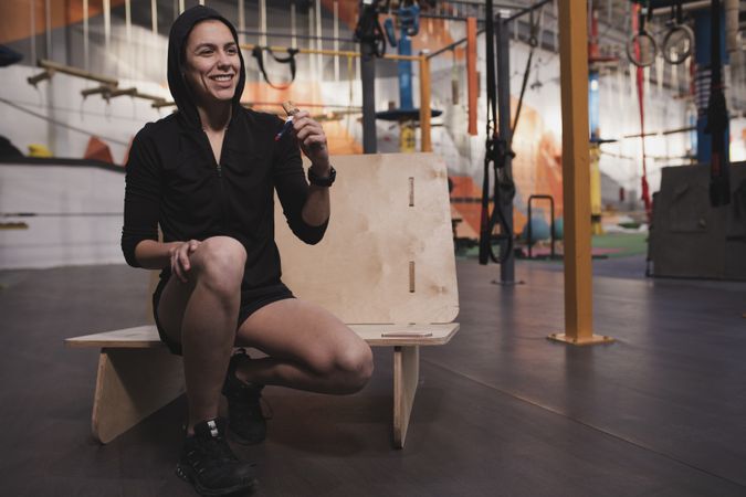 Smiling woman with energy bar in gym