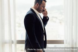 Businessman in hotel room having discussion over phone 4jovxb
