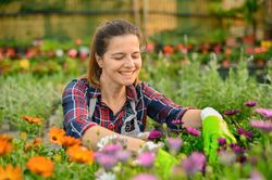 Happy woman sitting among flowers