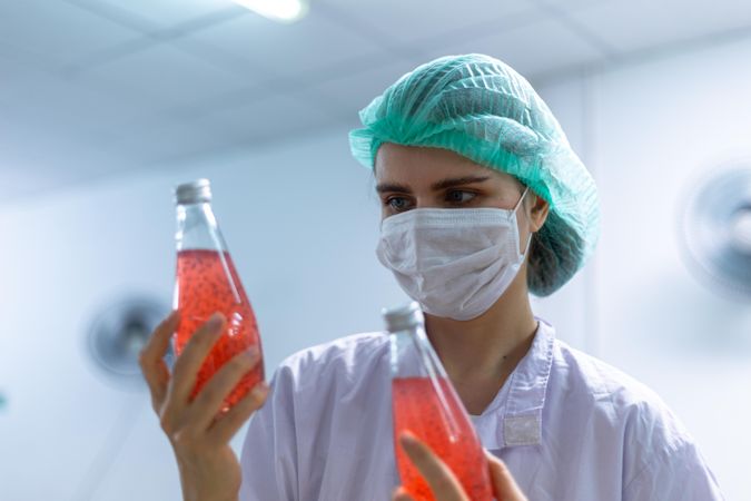 Woman checking drink bottles in factory