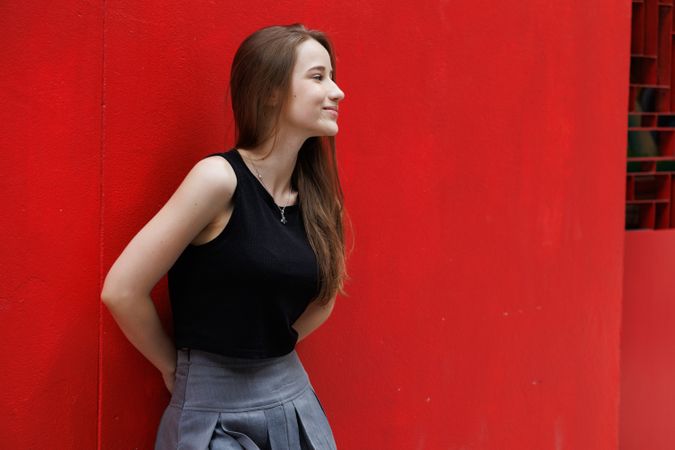 Woman standing with red background
