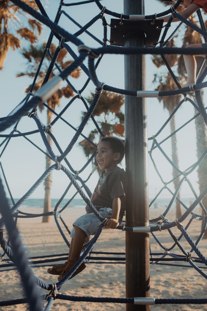 Funny Black boy on net on playground