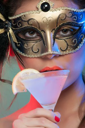 Woman in mask holding glass of drink