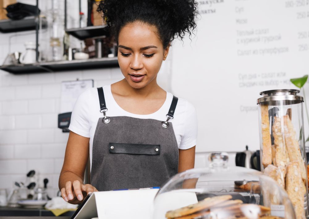 Female barista using tablet in shop
