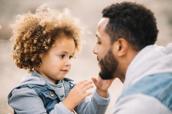 Black father playing with child on ground
