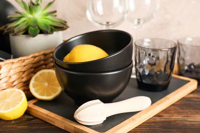Set of dinnerware with succulent plant and lemons on wooden table, space for text