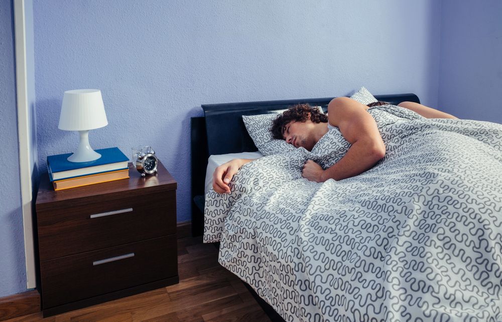 Couple sleeping in bed on their sides