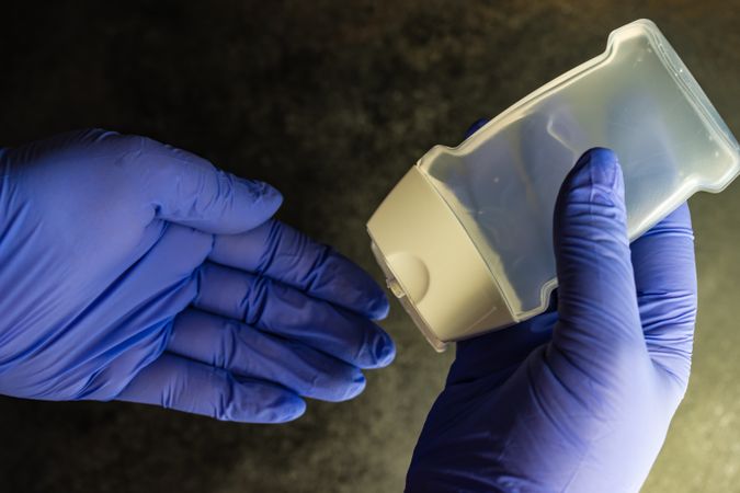 Top view of hands wearing purple latex gloves with antibacterial soap