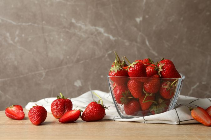 Bowl with tasty strawberry on wooden table. Summer berry