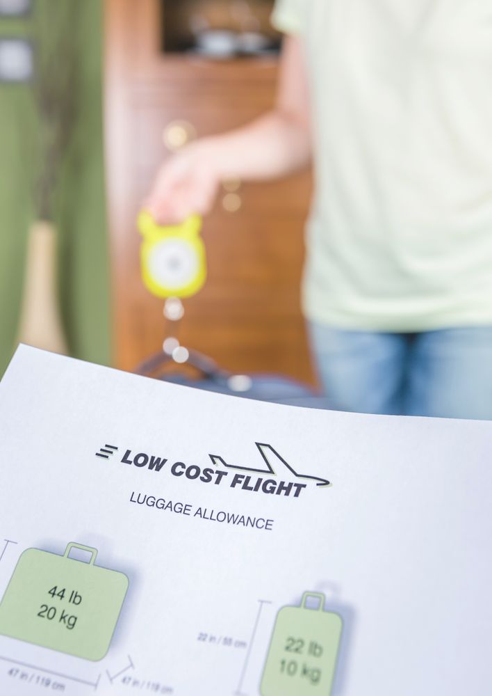 Woman checking luggage weight with a hand balance