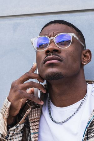 Stylish Black male using smartphone on street