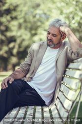 Portrait of a grey haired man, lost in thought on bench in a park 4Z18O5