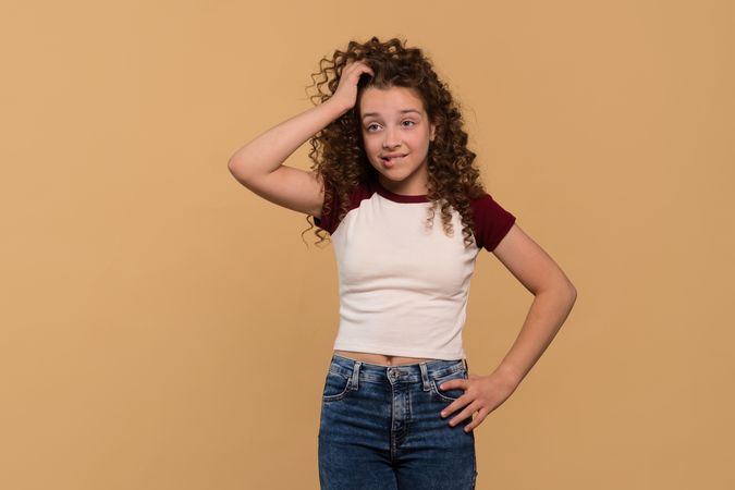 Young girl scratching her head, appearing puzzled