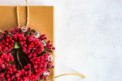 Holiday gift with red holly wreath and string
