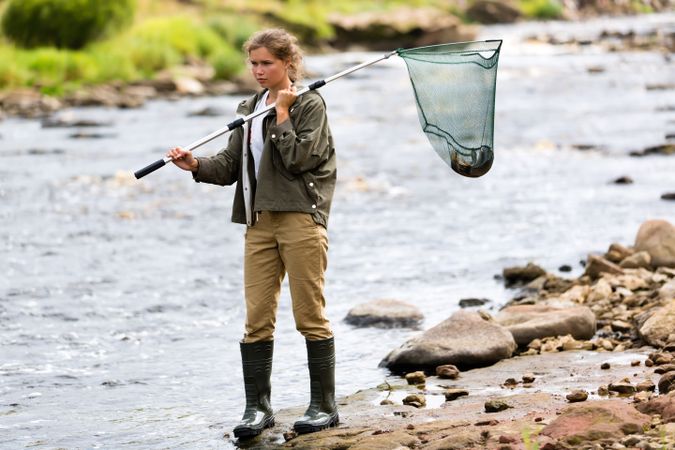 Female Fisherman Lifting Net from River