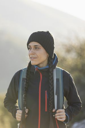 A young woman at the top of a mountain enjoys being out in nature