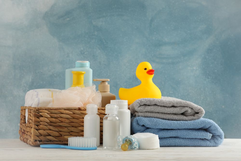 Baby hygiene accessories on wooden table against blue background