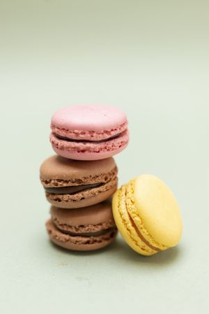 Chocolate, strawberry & lemon macaroons on a green table with copy space