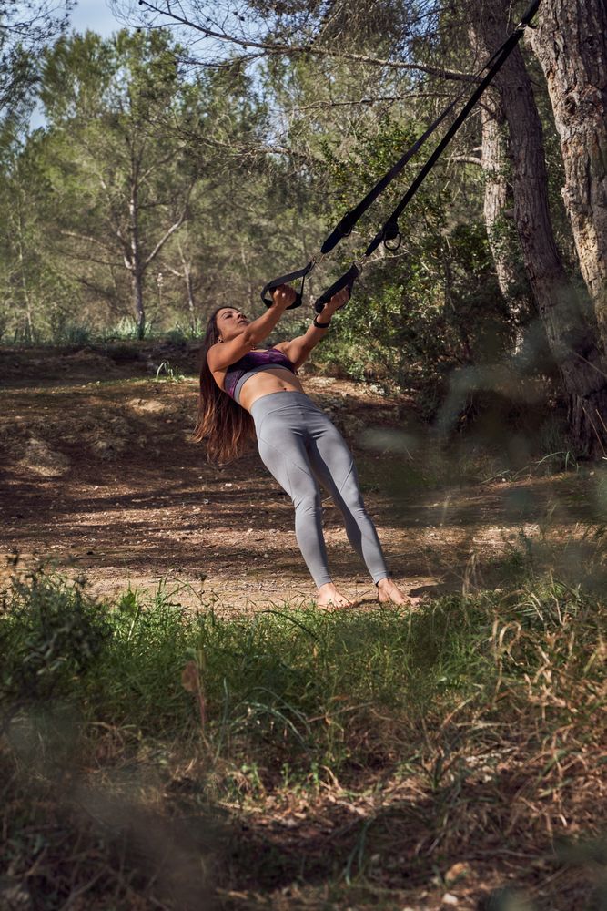 Barefoot sportswoman in activewear doing fitness in nature