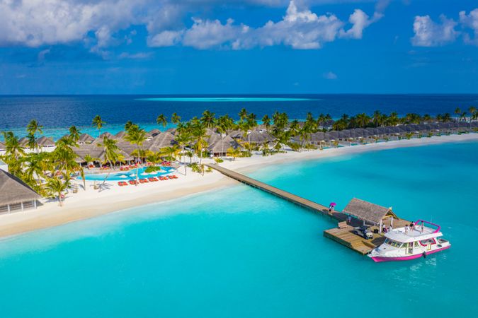 Beach holiday resort with long pier and boat, landscape