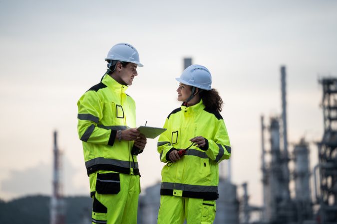 Engineer worker watching work monitor on digital tablet at refinery factory at night