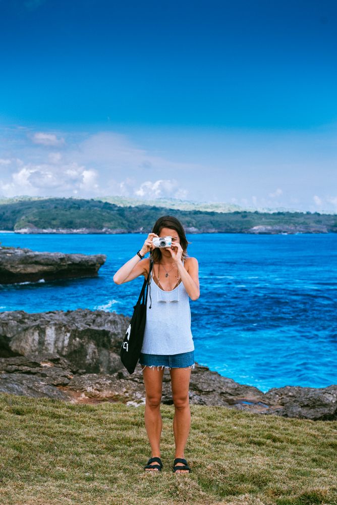 Woman with camera up to her eye in scenic Bali